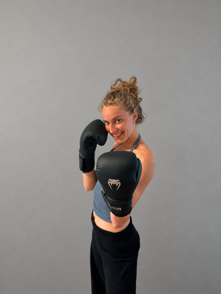 Lara, founder of G-FORCE, wearing pink-trimmed boxing gloves.