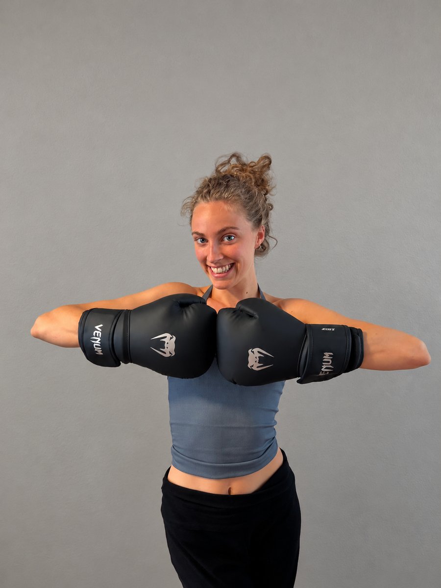 Lara, founder of G-FORCE, wearing pink-trimmed boxing gloves.