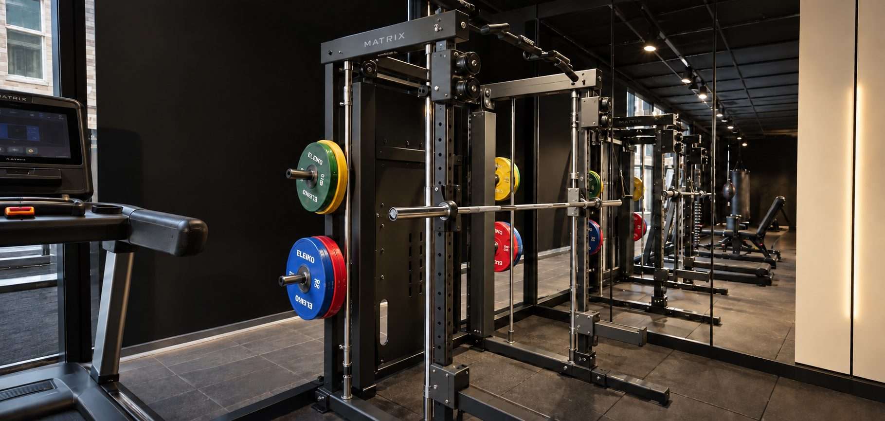 Squat racks with colourful weight plates in the G-Force strength area.